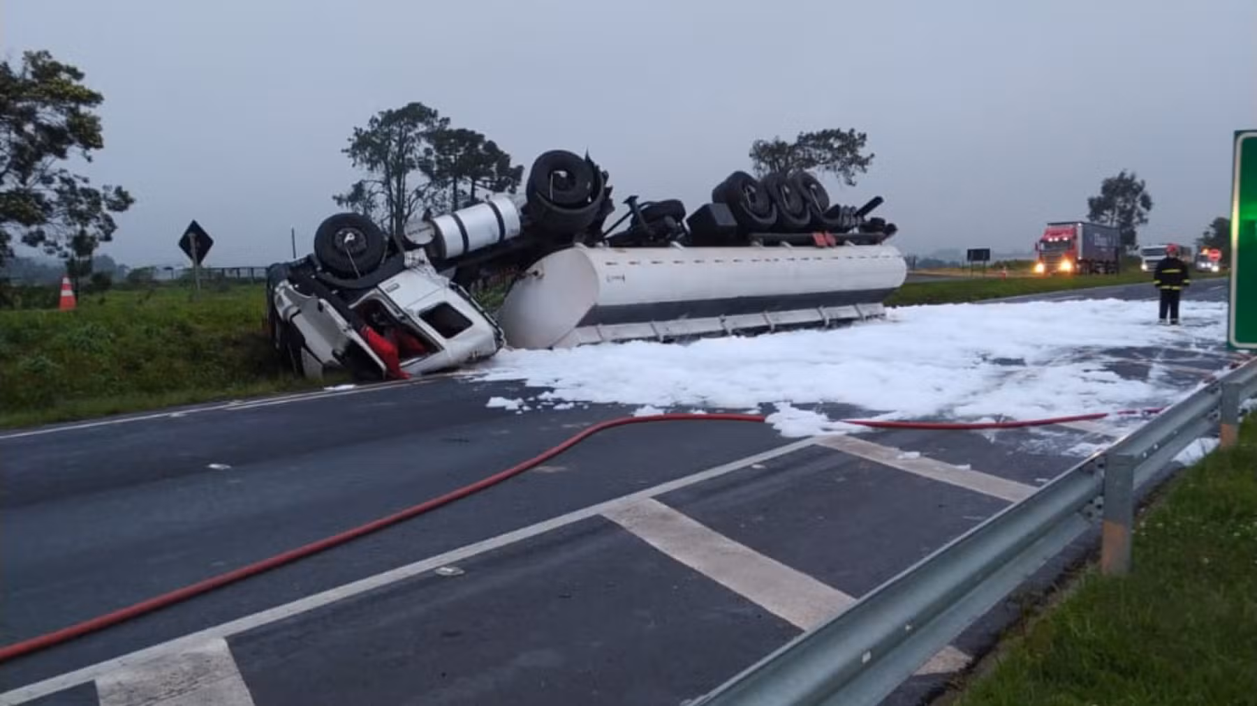 Motorista fica preso às ferragens e PR-151 é bloqueada após caminhão-tanque tombar e derramar carga de combustível na pista